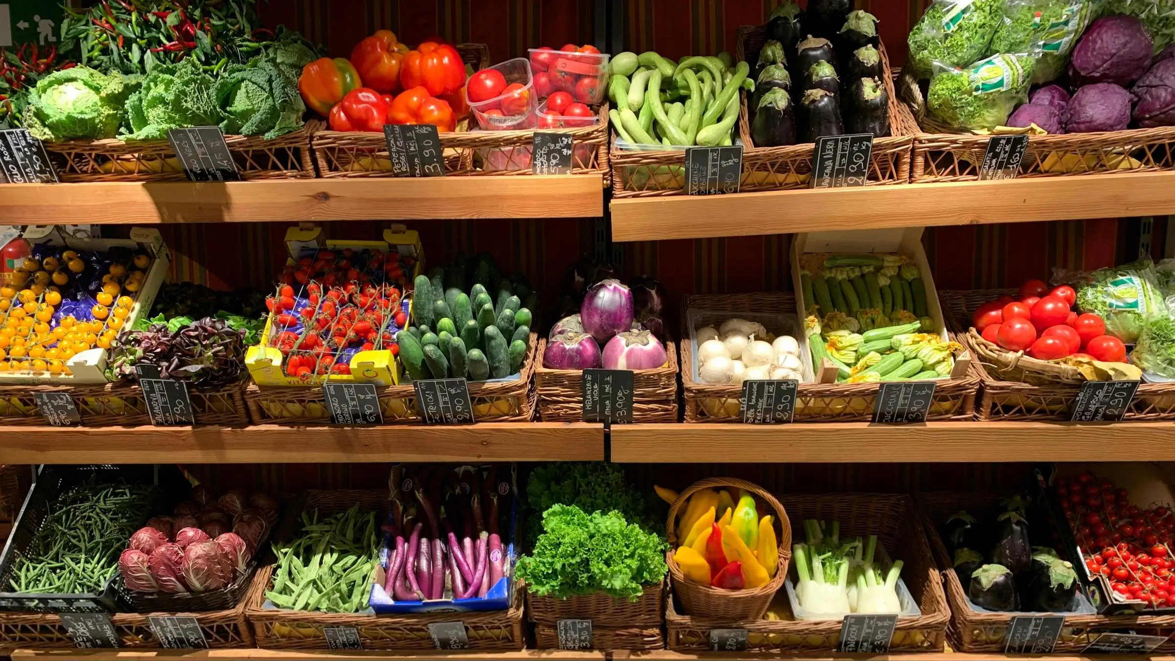Fresh vegetables on wooden shelves in a produce section